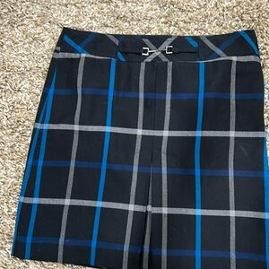 Fully lines skirt with front buckle at banded waist and front pleat. Side zipper